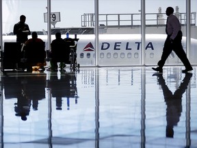 In this Thursday, Oct. 13, 2016, file photo, a Delta Air Lines jet sits at a gate at Hartsfield-Jackson Atlanta International Airport, in Atlanta.