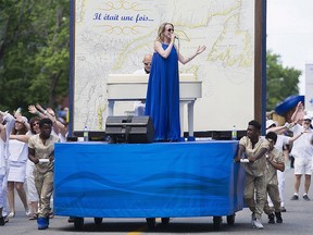 Annie Villeneuve entertains the crowd during the annual Saint-Jean-Baptiste day parade in Montreal, Saturday, June 24, 2017. Organizers of the Fete nationale parade are apologizing to people who were upset by the sight of black teenagers pushing a float carrying a white singer.
