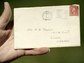 In this Thursday, June 15, 2017 photo, a letter, addressed to Mrs. H.H. Wheeler and postmarked in Des Moines in 1914, showed up in letter carrier Larry Schultz' batch of mail to deliver Thursday in Lincoln, Neb. Problem is: Grace Wheeler died in 1947, and her family home came tumbling down in 1965 to make way for the Nebraska Capitol's south parking lot. (Eric Gregory/The Journal-Star via AP)