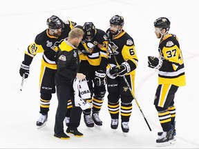 Pittsburgh Penguins forward Nick Bonino is helped off the ice after blocking a shot against the Nashville Predators on May 31.