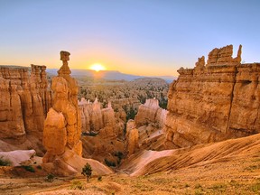 The sun rises above Thor's Hammer, left foreground, at Bryce Canyon National Park, Utah. The park is filled with tall, thin, limestone spires known as hoodoos.