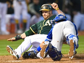 Stephen Vogt of the Oakland Athletics attempting to score from first base on a double by Mark Canha gets tagged out at home plate by Luke Maile of the Toronto Blue Jays in the bottom of the fifth inning at Oakland Alameda Coliseum Tuesday.