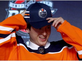 Kailer Yamamoto puts on an Edmonton Oilers hat at the NHL draft on June 23.