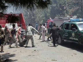 Afghans carry an injured man after a suicide car bombing in Helmand province southern of Kabul, Afghanistan, Thursday, June 22, 2017. The bomber struck outside a bank, targeting Afghan troops and government employees waiting to collect their salaries ahead of a major Muslim holiday and killing at least two dozen people, officials said. (AP Photo/Abdul Khaliq)