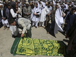 A man looks at the coffin of a victim who died in Wednesday's massive bombing, in Kabul, Afghanistan, Thursday, June 1, 2017. Afghans mourned the loss of family members, friends and colleagues on Thursday, a day after the truck bomb exploded in the capital leaving at least 90 people dead and more than 450 others wounded in one of the worst extremist attacks since the drawdown of foreign forces from Afghanistan in 2014.