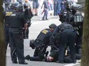 A man is arrested by Portland Police during demonstrations for and against US President Donald Trump in downtown Portland, Oregon, June 4, 2017.
Four separate demonstrations occurred in adjacent parks, including a pro-Trump rally, bringing a heightened police force.