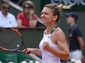 Romania's Simona Halep celebrates after winning against Spain's Carla Suarez Navarro their tennis match at the Roland Garros 2017 French Open on June 5, 2017 in Paris.