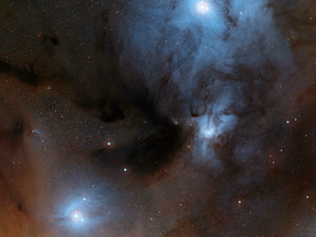 The European Southern Observatory shows a wide-field view of a spectacular region of dark and bright clouds, forming part of a region of star formation in the constellation of Ophiuchus (The Serpent Bearer).