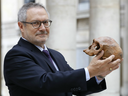 French paleoanthropologist Jean-Jacques Hublin poses with the casting of a skull of Homo Sapiens discovered in Morocco on June 6, 2017 in Paris. 