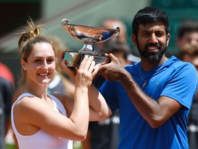 India's Rohan Bopanna (R) and Canada's Gabriela Dabrowski pose with their trophy after winning their mixed doubles tennis match against Colombia's Robert Farah and Germany's Anna-Lena Groenefeld at the Roland Garros 2017 French Open on June 8, 2017 in Paris.