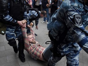 Russian police officers detain an unidentified protestor in central Moscow on June 12, 2017.  Authorities have detained Russian opposition politician Alexei Navalny and hundreds of his supporters, as they mounted demonstrations across the nation against government corruption.
