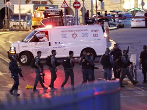 Israeli security forces and an ambulance attend the scene of an attack outside Damascus Gate in Jerusalem's Old City on June 16, 2017. An Israeli policewoman was stabbed and critically wounded in the attack, police said, with security forces shooting three suspected assailants.