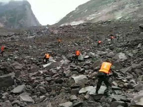 This screengrab taken from a broadcast by China's State broadcaster CCTV on June 24, 2017 shows rescuers looking for survivors after a landslide hit the village of Xinmo in China's Sichuan province.