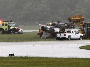 A military jet is attended to after flipping over at the Dayton International Airport on Friday, June 23, 2017, in Dayton, Ohio. (Ty Greenlees /Dayton Daily News via AP)