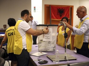 Election staff count ballots in Tirana, Albania, Monday, June 26, 2017. Albania's left-wing Socialist Party appears headed for a new governing mandate following elections which are crucial in the country's bid to launch membership negotiations with the European Union. (AP Photo/Hektor Pustina)