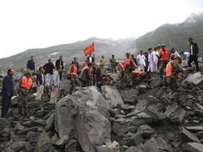 Emergency personnel work at the site of a landslide in Xinmo village in Maoxian County in southwestern China's Sichuan Province, Saturday, June 24, 2017.