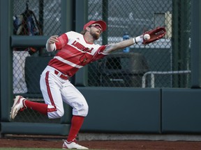 Louisville right fielder Colin Lyman misses a ball hit by Florida'a Mike Rivera for a double, during the fourth inning of an NCAA College World Series baseball game in Omaha, Neb., Tuesday, June 20, 2017. (AP Photo/Nati Harnik)