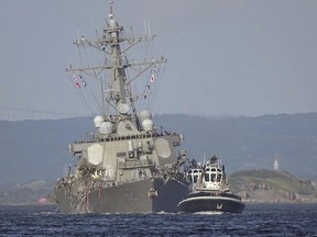 The damaged USS Fitzgerald is being towed by a tugboat in the waters near the U.S. Naval base in Yokosuka, southwest of Tokyo, after the U.S. destroyer collided with the Philippine-registered container ship ACX Crystal in the waters off the Izu Peninsula Saturday, June 17, 2017.