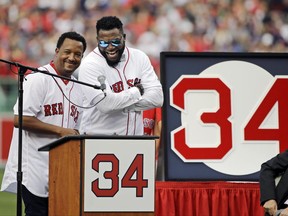 Boston Red Sox baseball great David Ortiz, right, laughs with Hall of Fame pitcher Pedro Martinez, Friday, June 23, 2017, at Fenway Park in Boston as the team retired Ortiz's jersey No. 34 worn when he led the franchise to three World Series titles. It is the 11th number retired by the Red Sox. (AP Photo/Elise Amendola)
