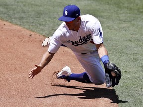Los Angeles Dodgers second baseman Austin Barnes fields a ball hit by Colorado Rockies' Charlie Blackmon during the second inning of a baseball game in Los Angeles, Sunday, June 25, 2017. Blackmon was out at first. (AP Photo/Chris Carlson)