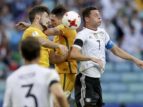 Germany's Julian Draxler, right, fight an aerial duel wit two Australian players during the Confederations Cup, Group B soccer match between Australia and Germany, at the Fisht Stadium in Sochi, Russia, Monday, June 19, 2017. (AP Photo/Thanassis Stavrakis)