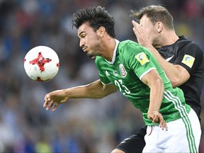 Mexico's Oswaldo Alanis, left, is challenged by New Zealand's Tommy Smith during the Confederations Cup, Group A soccer match between Mexico and New Zealand, at the Fisht Stadium in Sochi, Russia, Wednesday, June 21, 2017. (AP Photo/Martin Meissner)