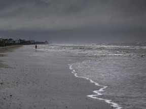 A woman walks along the beach the morning after Tropical Storm Cindy made landfall Thursday, June 22, 2017, on the Bolivar Peninsula, Texas. (Michael Ciaglo/Houston Chronicle via AP)