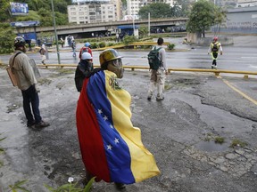 Demonstrators look back during protests in Caracas, Venezuela, Thursday, June 29, 2017. Demonstrators are taking the the streets after three months of continued protests that has seen the country's chief prosecutor Luisa Ortega barred from leaving the country and her bank accounts frozen by the Supreme Court following her mounting criticisms of President Nicolas Maduro. (AP Photo/Ariana Cubillos)