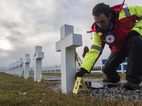 In this Sunday, June 18, 2017 photo provided by the International Committee of the Red Cross, ICRC, Asier izaguirre Pasaban, a forensic logistician with the IRC, works at the Argentine memorial cemetery containing the remains of 237 Argentine combatants killed during the 1982 war between Argentina and Britain, in Darwin, on the Falkland Islands. A forensics team from ICRC exhumed on Tuesday June 20 the first body of an unidentified Argentine soldier buried in a military cemetery on the Falkland Islands. (Didier Revol/ICRC via AP)