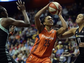FILE - In this June 14, 2017, file photo, Connecticut Sun's Alyssa Thomas (25) splits the defense of New York Liberty's Tina Charles, left, and Kiah Stokes during a WNBA basketball game, in Uncasville, Conn. Connecticut spent 17 of 19 days on the road and had to play Minnesota three times in the first 10 games and yet the Sun are sitting at .500.  (Sean D. Elliot/The Day via AP, File)
