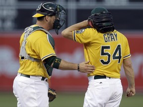 Oakland Athletics catcher Stephen Vogt, left, speaks with pitcher Sonny Gray (54) during the first inning of a baseball game against the Houston Astros on Tuesday, June 20, 2017, in Oakland, Calif. (AP Photo/Ben Margot)