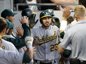Oakland Athletics' Matt Joyce (23) celebrates in the dugout after his home run off Chicago White Sox starting pitcher Mike Pelfrey during the fifth inning of a baseball game Friday, June 23, 2017, in Chicago. (AP Photo/Charles Rex Arbogast)