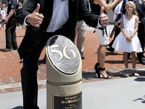 Former Chicago White Sox pitcher Mark Buehrle poses with a monument in his honor after his No. 56 was retired during ceremonies before a baseball game between the White Sox and the Oakland Athletics Saturday, June 24, 2017, in Chicago. (AP Photo/Charles Rex Arbogast)