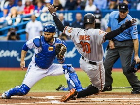 Baltimore Orioles' Adam Jones beats Blue Jays catcher Russell Martin to the plate to score during first inning action at Rogers Centre in Toronto, on Tuesday night.
