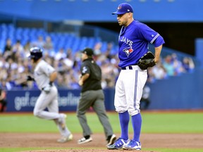 Blue Jays starting pitcher Marco Estrada reacts as the Tampa Bay Rays’ Taylor Featherston rounds the bases on a solo home run during the third inning in Toronto on Tuesday night.