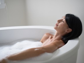 A woman relaxes in what may or may not be beer foam.