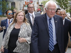 FILE--In this July 28, 2016 file photo, Sen. Bernie Sanders, I-Vt. and his wife Jane walk through downtown in Philadelphia during the final day of the Democratic National Convention. Sanders and his wife Jane O'Meara Sanders have hired lawyers in the face of federal investigations into the finances of the now-defunct Burlington College, which closed last year due, many feel, to debts incurred when Jane Sanders entered into an ill-advised real estate deal. (AP Photo/John Minchillo, File)