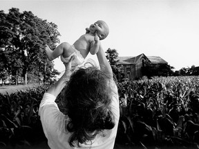 Lambton County, Ontario. 1993. Isaac TOWELL in the first few months of his recorded history being held above a corn field a few hundred yards down the road from his home and in front of an abandoned pioneer farmhouse.