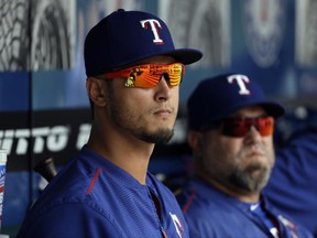 Texas Rangers' Yu Darvish, left, of Japan, and a member of the team's staff watch from the dugout during the sixth inning of a baseball game against the Toronto Blue Jays, Thursday, June 22, 2017, in Arlington, Texas. (AP Photo/Tony Gutierrez)