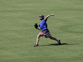 A pair of balls thrown by other pitchers go sailing by as Texas Rangers starting pitcher Cole Hamels throws during batting practice before a baseball game against the Toronto Blue Jays on Tuesday, June 20, 2017, in Arlington, Texas. (AP Photo/Tony Gutierrez)