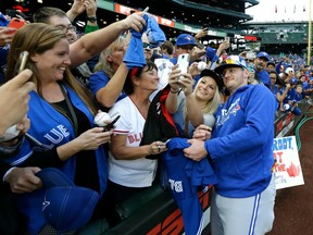 In this Sept. 19, 2016 file photo, Toronto Blue Jays 3B Josh Donaldson (right) poses for a photo with fans in Seattle.