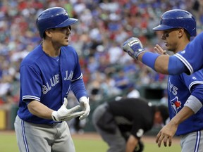 Toronto Blue Jays' Darwin Barney and Ryan Goins, right, celebrate Barney's two-run home run that scored Goins during the first inning against the Texas Rangers on Wednesday in Arlington, Texas.