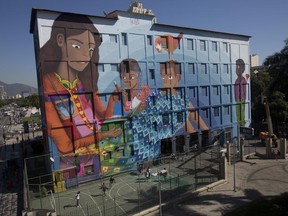 A giant graffiti titled "Contos" or "Tales", created by 19-year-old Luna Buschinelli, covers an exterior of the Rivadavia Correa municipal school, in Rio de Janeiro, Brazil, Monday, June 19, 2017. Buschinelli hopes to break a Guinness World Record as the largest graffiti made by a woman. (AP Photo/Silvia Izquierdo)