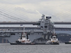 HMS Queen Elizabeth, one of two new aircraft carriers for the Royal Navy, is assisted by tugs on the Firth of Forth after leaving the Rosyth dockyard, Scotland, near Edinburgh to begin her sea worthiness trials, Monday June 26, 2017. Naval staff and contractors lined the deck of HMS Queen Elizabeth as the 280-metre, 65,000-tonne aircraft carrier moved in a three-hour operation. (Andrew Milligan/PA via AP)