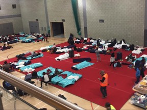People gather in a leisure centre in Swiss Cottage, north London, Saturday June 24, 2017, after the local council evacuated some 650 homes overnight. Camden Borough Council said in a statement Saturday that it housed many of the residents at two temporary shelters while many others were provided hotel rooms, after inspectors found fire safety issues in housing towers, following the inferno in a west London apartment block that killed 79. (AP Photo)