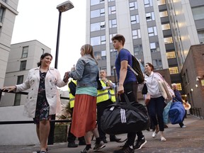 Residents leave a tower block on the Chalcots Estate in Camden, London, Friday evening, June 23, 2017, as the building is evacuated in the wake of the Grenfell Tower fire to allow "urgent fire safety works" to take place. More than 800 homes in tower blocks on the council estate in Camden, north London, are be evacuated.