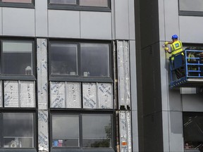 Workers remove cladding from Whitebeam Court, in Pendleton, Manchester, Monday June 26, 2017. Dozens of apartments and even hospitals in the UK have since found to be covered in the same, potentially deadly material.