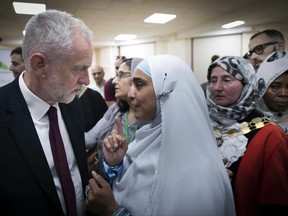 Labour leader Jeremy Corbyn, left, meets locals at Finsbury Park Mosque in north London, after an incident where where a van struck pedestrians, in London, Monday June 19, 2017. British authorities and Islamic leaders moved swiftly to ease concerns in the Muslim community after a man plowed his vehicle into a crowd of worshippers outside a north London mosque early Monday, injuring at least nine people.﻿﻿ (Stefan Rousseau/Pool Photo via AP)