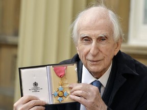 FILE - In this Oct. 27, 2015 file photo, Michael Bond, the creator of Paddington Bear, poses with his Commander of the Order of the British Empire (CBE). Publisher HarperCollins says Michael Bond, creator of globe-trotting teddy Paddington bear, died on Tuesday June 27, 2017, aged 91. (John Stillwell/PA via AP)