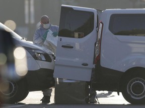 A member of emergency services and forensic officers works on a road near Finsbury Park station after a vehicle struck pedestrians in north London, Monday, June 19, 2017. A vehicle struck pedestrians near a mosque in north London early Monday morning. (AP Photo/Tim Ireland)